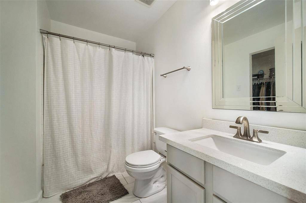Featuring a crisp white vanity, modern fixtures, and a shower/tub combo, this ensuite bath provides both style and functionality.