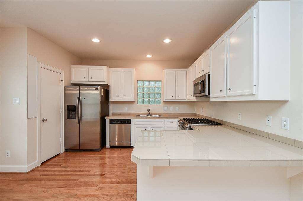 Gleaming countertops of (granite? quartz?) offer sturdy, attractive work surfaces at every turn.