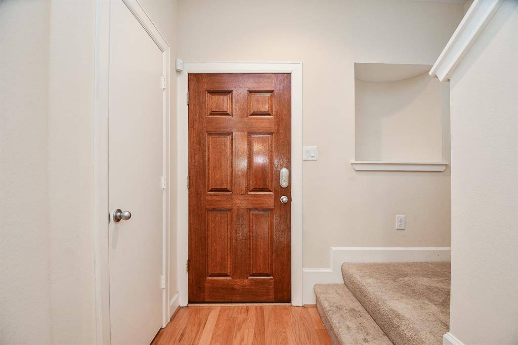 This is the main entrance from the inside of the light, bright, recently painted and sparkling interior! Pale earth tones grace walls and floors of (wood, wood-look tile? laminate?), with a peek, right, of the introduction of the generously carpeted stairs.