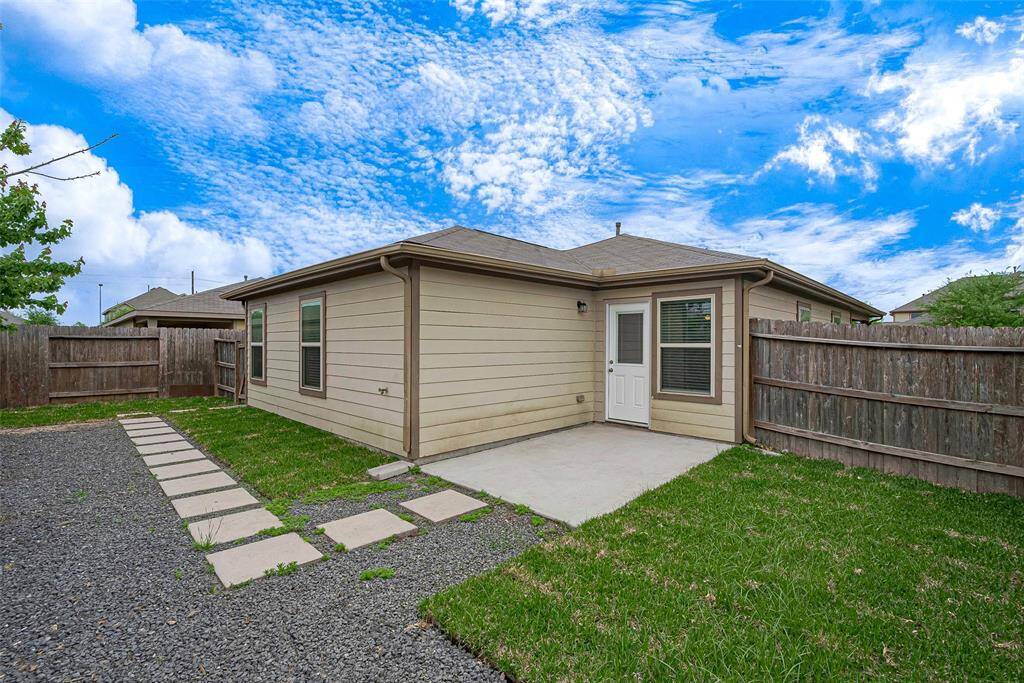 Charming backyard with a paved patio, grassy area, and privacy fencing. Ideal for outdoor relaxation and gatherings.