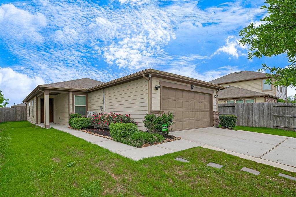 This well-maintained, single-story home features a two-car garage, neatly landscaped front yard, and a welcoming covered entry. The property is framed by a wooden fence, providing privacy and a cozy suburban feel.