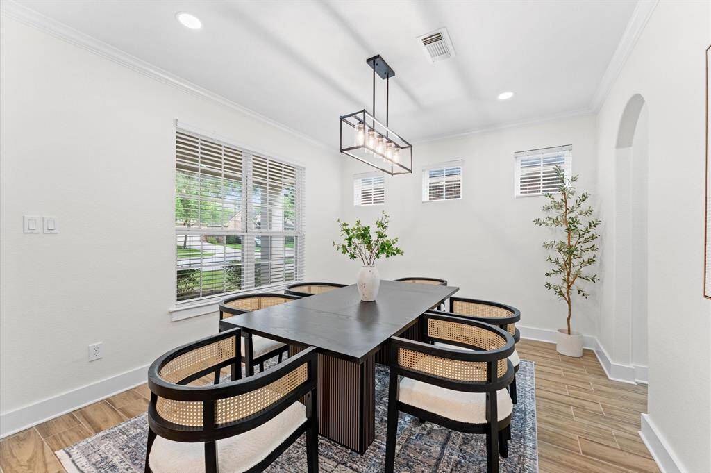 Expansive primary bedroom with upgraded light fixtures, new flooring, and new paint.