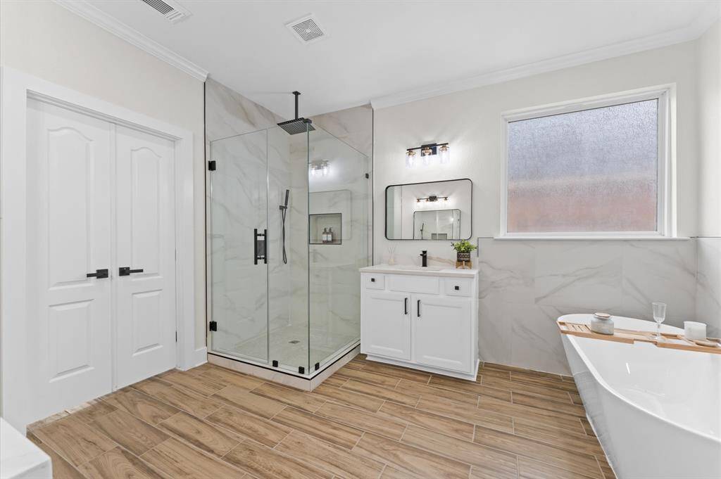 Primary Bathroom – Spa-like ensuite with a freestanding soaking tub, seamless glass shower, dual vanities, quartz countertops, and a massive walk-in closet.