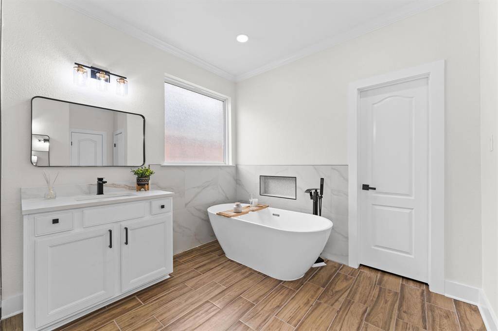 Primary Bathroom – Spa-like ensuite with a freestanding soaking tub, seamless glass shower, dual vanities, quartz countertops, and a massive walk-in closet.