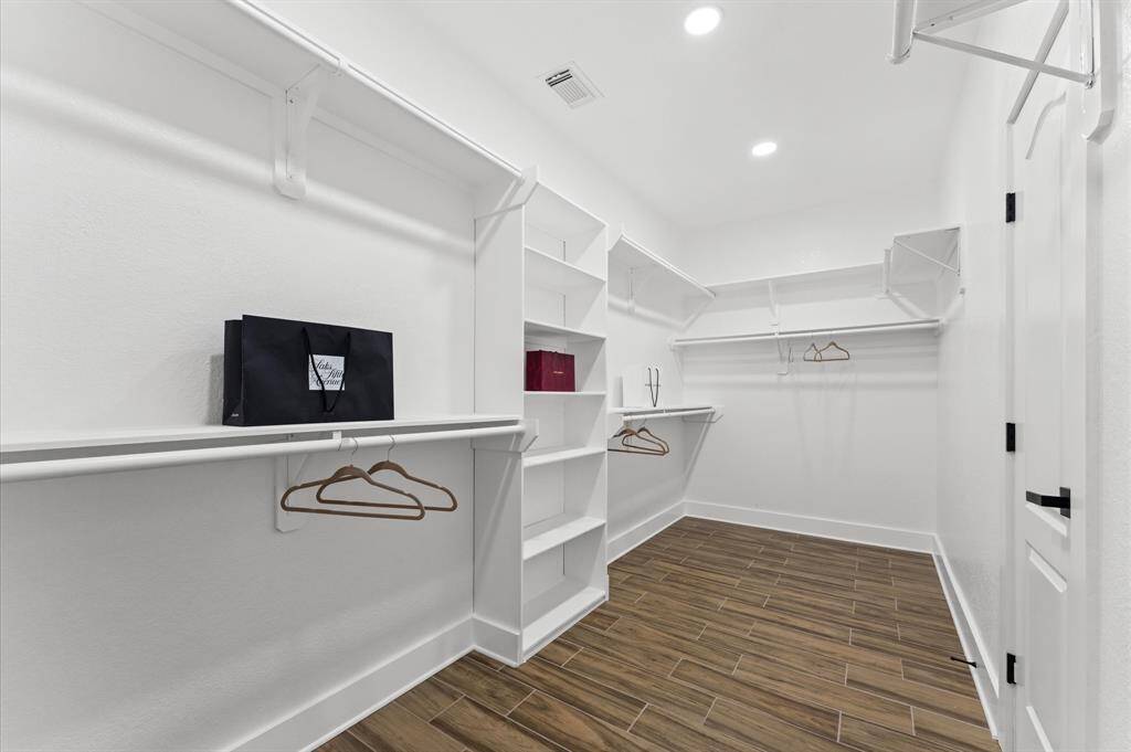 Primary Bathroom – Spa-like ensuite with a freestanding soaking tub, seamless glass shower, dual vanities, quartz countertops, and a massive walk-in closet.