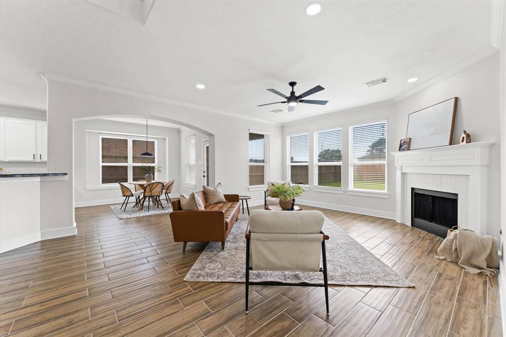 Spacious and inviting family room with a gas fireplace, oversized windows, new light fixtures and fresh paint.