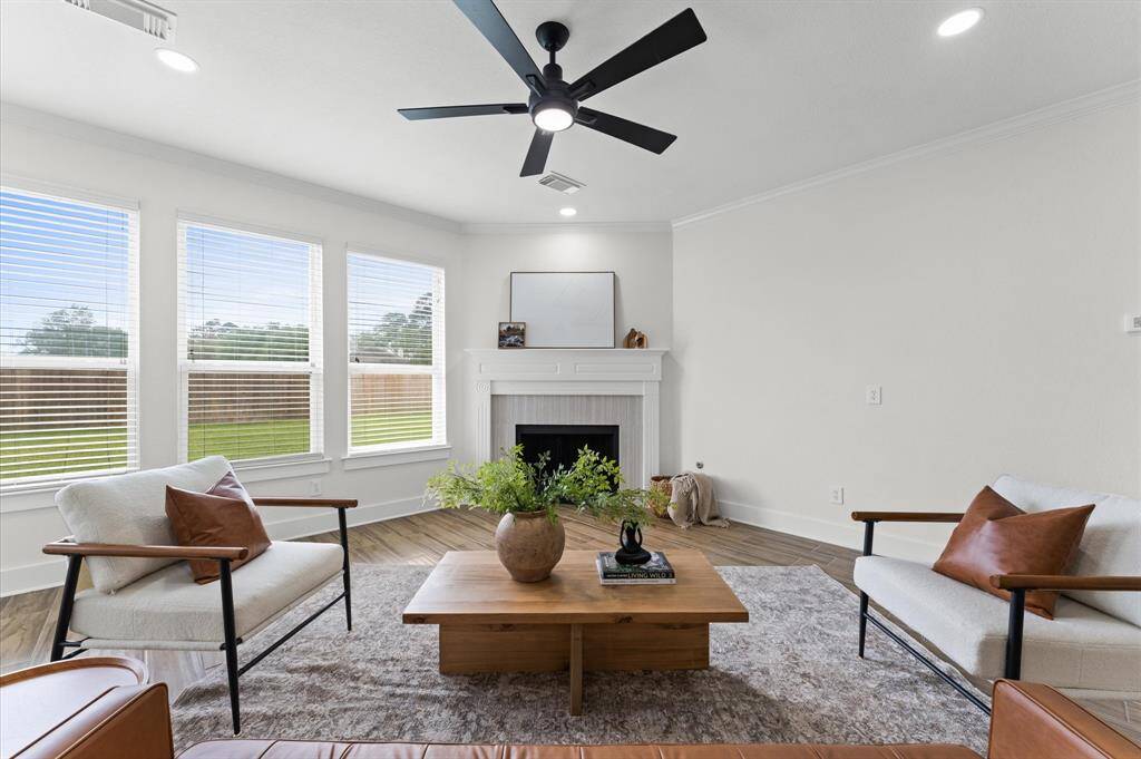 Spacious and inviting family room with a gas fireplace, oversized windows, new light fixtures and fresh paint.