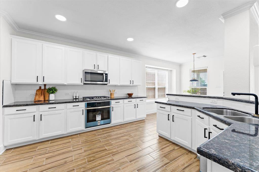 Completely remodeled with white shaker cabinetry, black hardware, quartz countertops, and brand-new stainless-steel appliances, including a 5-burner gas cooktop, Wi-Fi-enabled oven, and dishwasher.