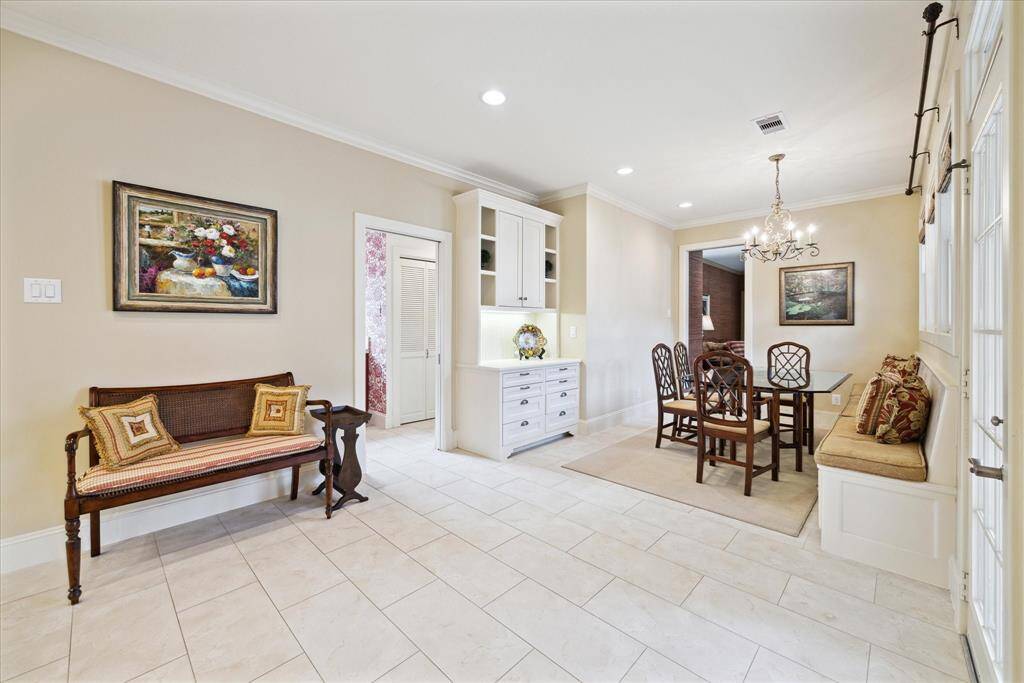 The pocket door to the left has accesses the laundry room and mudroom. It also connects   the garage to the home. The custom cabinetry off the Breakfast Room is ideal for storage, as well as   serving as a drop zone when entering from the garage. So, equally beautiful and functional!