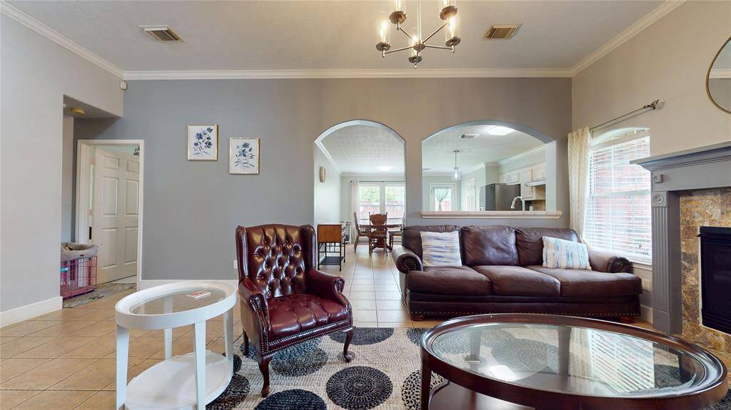 1309 Bayswater Dr, Living room area facing the kitchen area, soft gray walls and crown molding throughout.