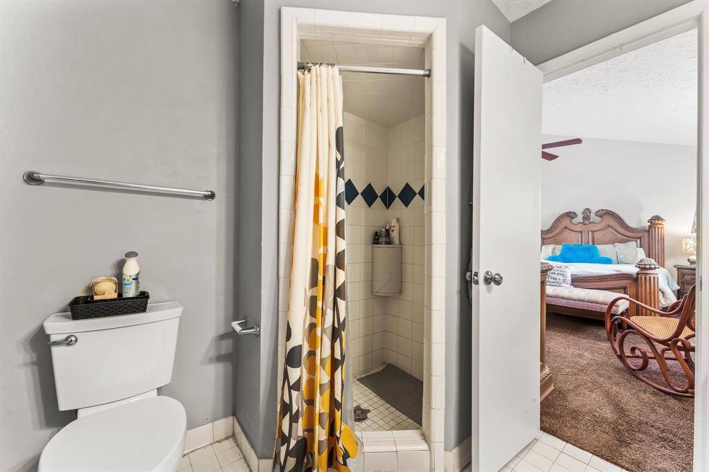 En suite bathroom with walk-in tiled shower, modern fixtures, and direct access to the spacious primary bedroom—designed for both comfort and privacy.