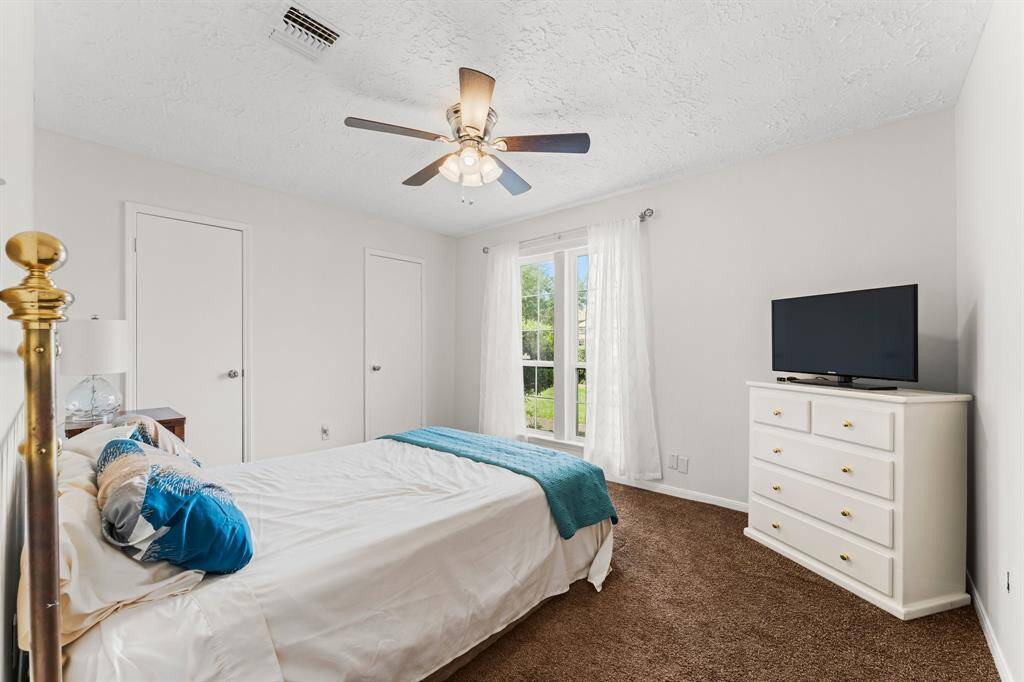 Bright and serene secondary bedroom with soft natural light, neutral tones, and dual closets—ideal for guests, a home office, or personal retreat.