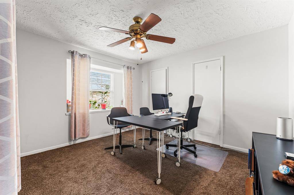 Versatile third bedroom currently set up as a home office, featuring a large window for natural light, ample closet storage, and neutral tones ideal for productivity or relaxation.