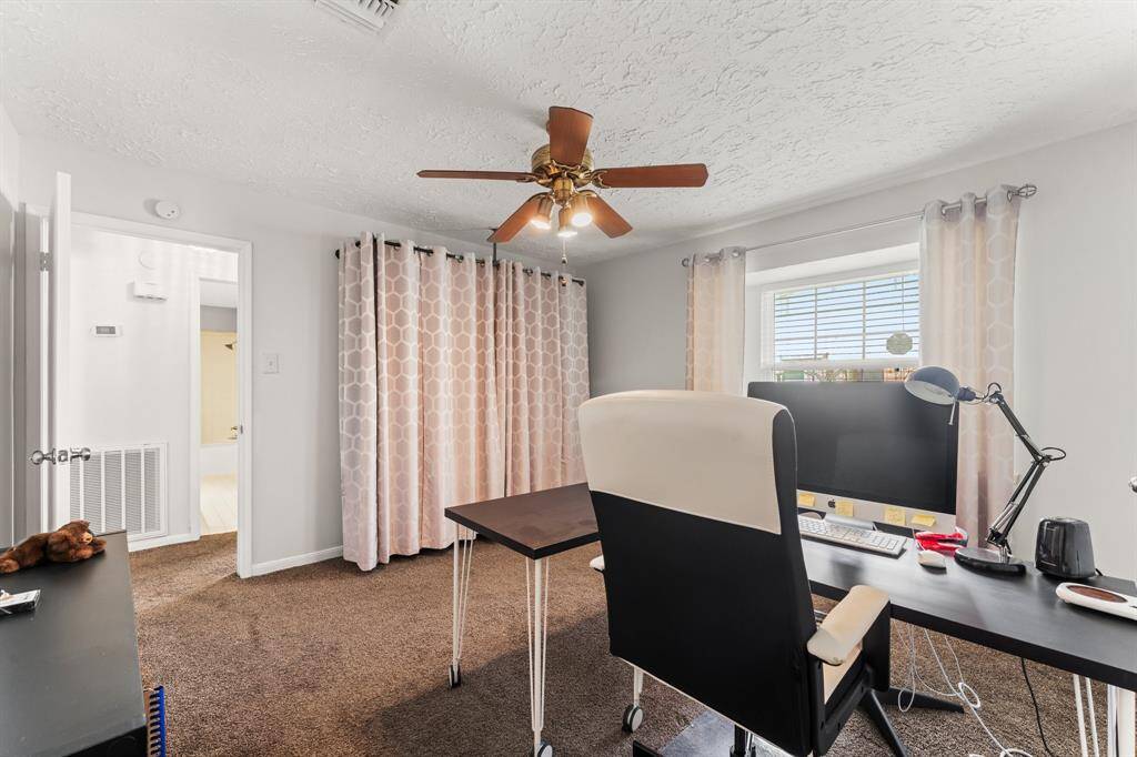 This flexible third bedroom, currently used as a home office, offers great lighting and a ceiling fan—perfect for work-from-home needs or easily converted into a guest room.