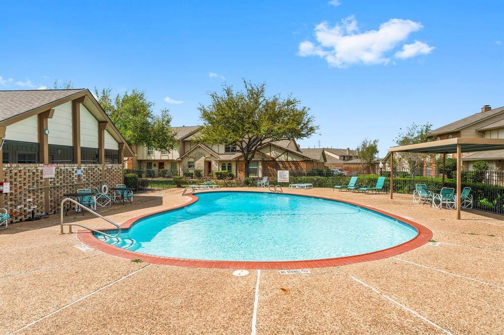 Resort-style community pool surrounded by lounge chairs, shaded seating, and beautiful landscaping—perfect for relaxing weekends and enjoying sunny days close to home.