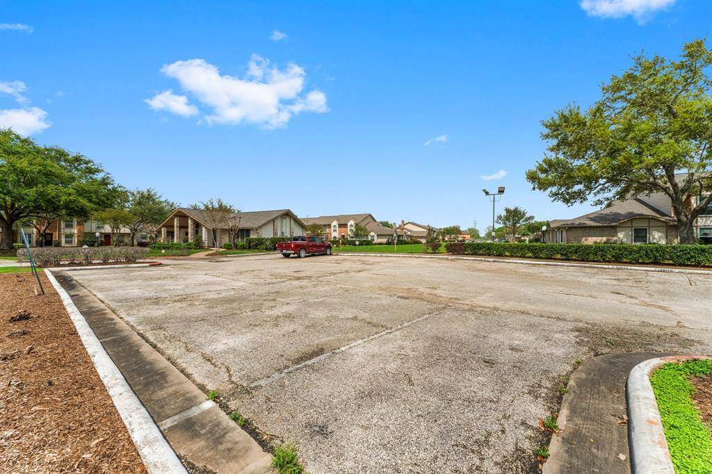 Ample community parking area surrounded by well-kept landscaping and charming homes—offering convenience and easy access for residents and guests alike.