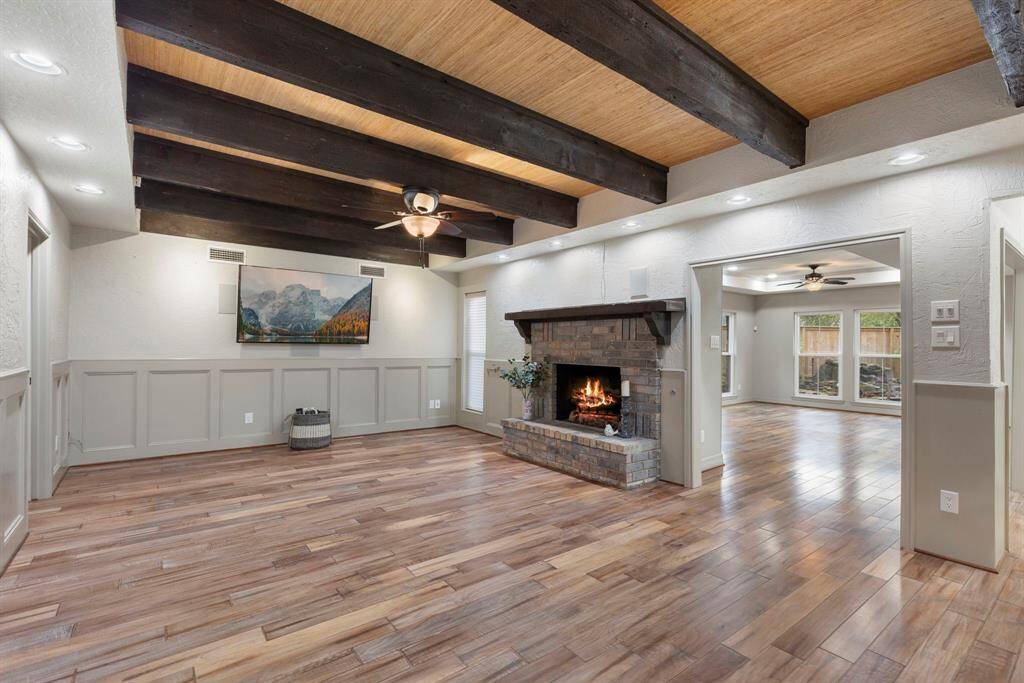 Open concept living room with gas fireplace and engineered wood flooring