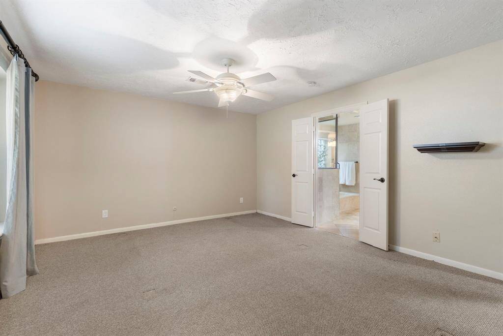 Primary bedroom with professionally clean carpets and ceiling fan