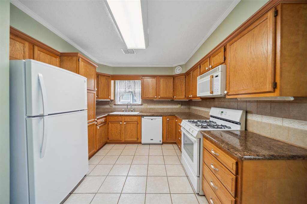 Kitchen has tile floors, granite counter tops & includes a refrigerator