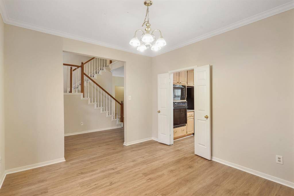 Looking back, the wide staircase featuring wooden handrails and white balusters stands as a stunning focal point.