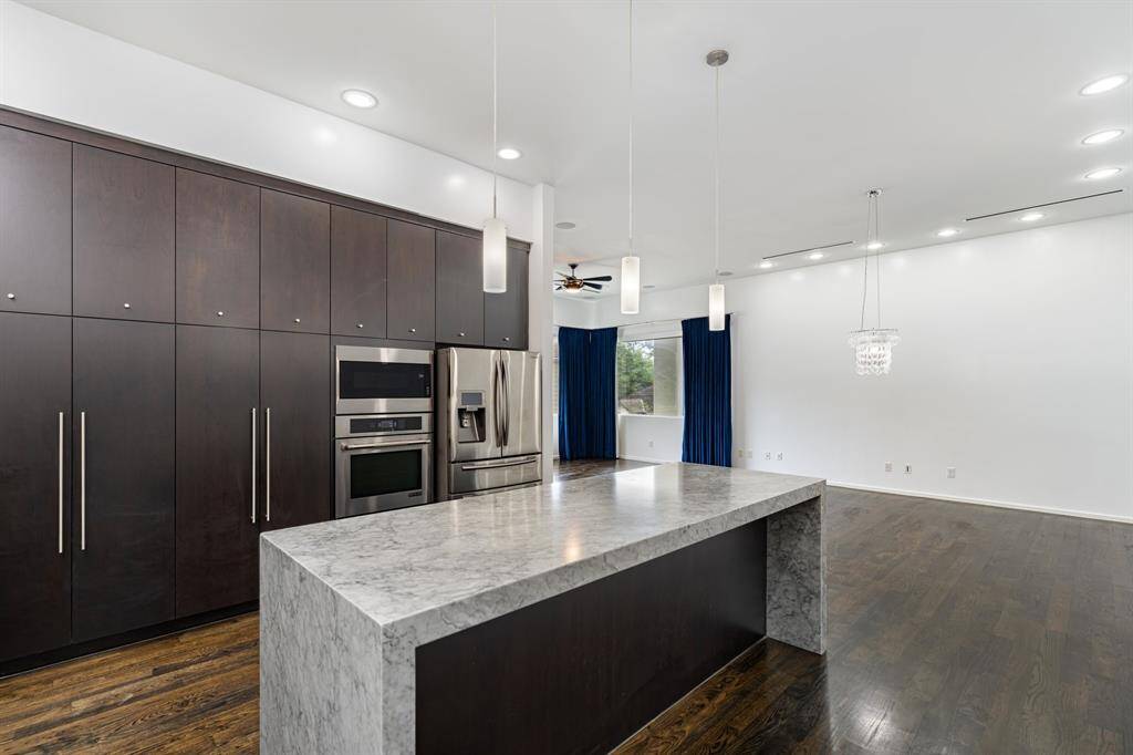 The stunning chef's kitchen features Jenn-Air appliances, an oversized waterfall island and rich cabinetry.