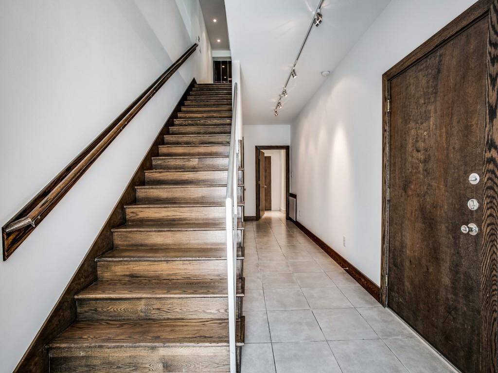 Stairs leading to the second floor, garage entrance, hallway to secondary bedroom and storage closet.