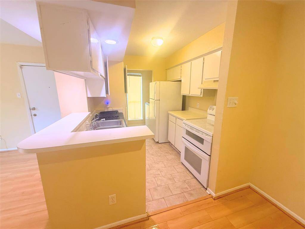 The kitchen has a double oven and fridge.