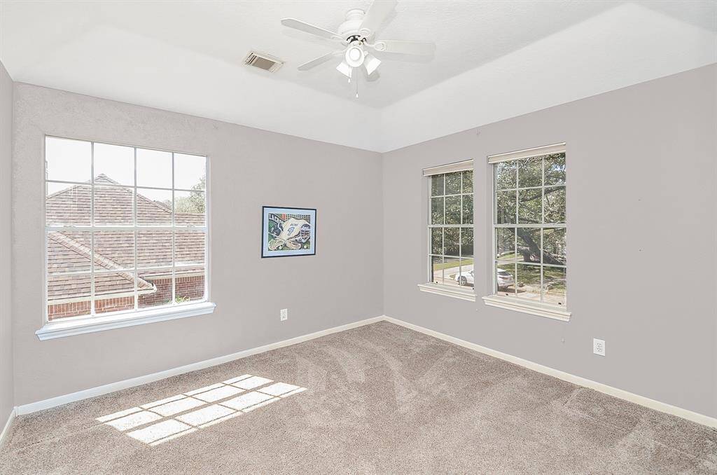 First of two upstairs bedrooms, this light and bright room has views of cul-de-sac and features raised ceilings, ceiling fan and a walk in closet