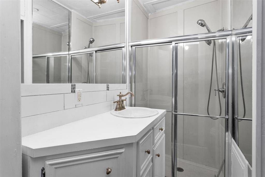 Bathroom #1 boasts a walk-in shower with modern finishes.