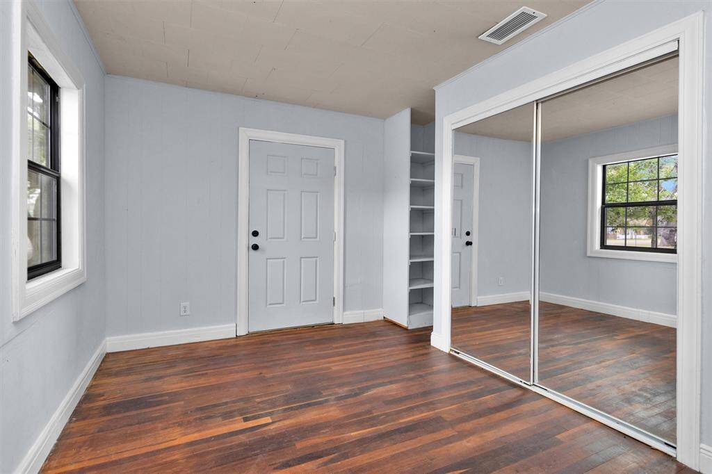 Formal living area featuring built-in shelving, and a large closet with sliding mirror doors.
