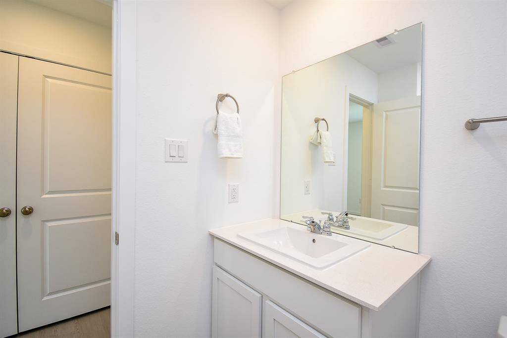 Modern white cabinetry carriedthroughout the baths.