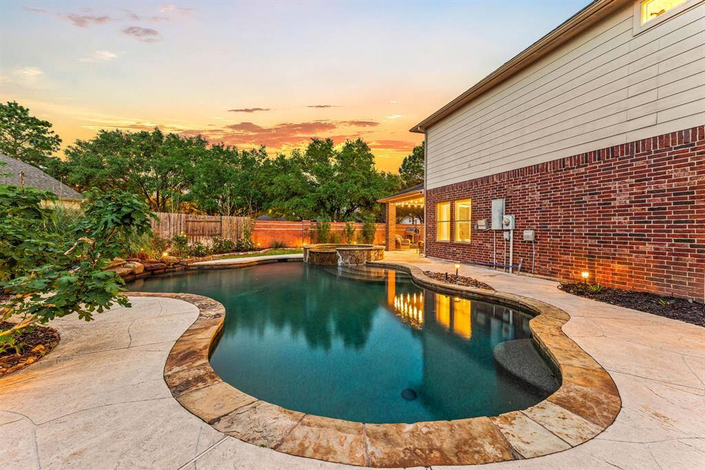 This inviting backyard features a covered patio with a scenic view of lush greenery. Ideal for relaxation and entertaining.