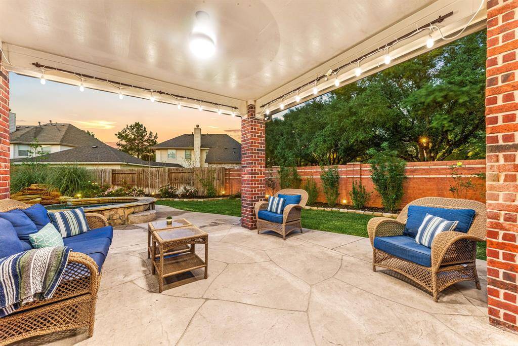 This photo showcases a charming backyard with a spacious patio area. The well-maintained lawn and cozy lighting create a welcoming atmosphere, perfect for outdoor gatherings.
