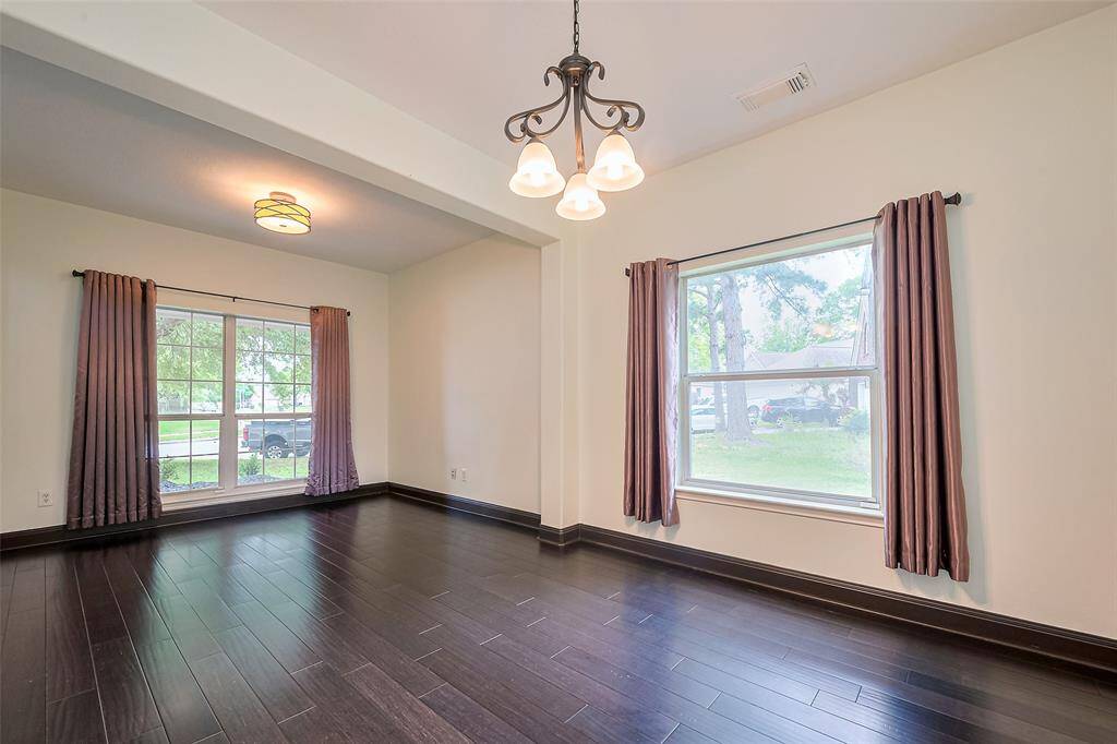 Charming two-story brick home with a welcoming front yard and driveway. Features include a two-car garage, mature trees, and a well-maintained lawn, perfect for family living.