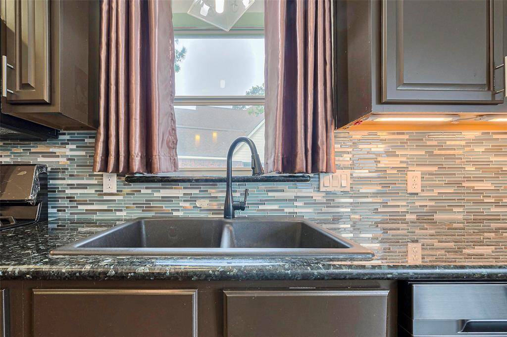 Charming two-story brick home with a welcoming front porch and well-maintained landscaping. Features include large windows, a mature tree, and an inviting entrance, ideal for family living.