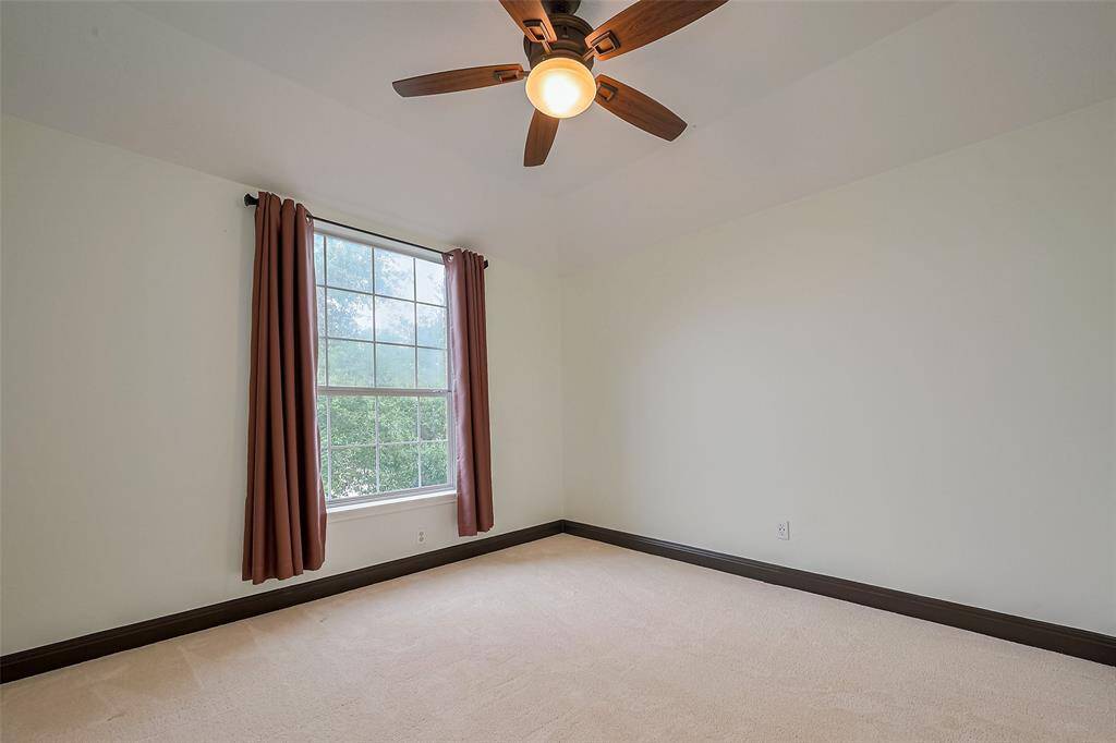 Cozy dining area with dark hardwood floors, soft lighting, and an open doorway leading to a modern kitchen with stainless steel appliances.