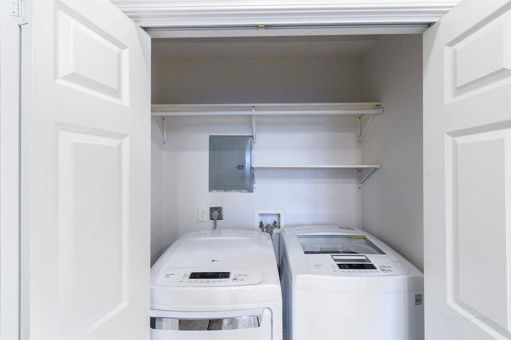 Behind double doors you'll find your spacious laundry room. Features include overhead shelving and hanging rods. An added bonus, the washer and dryer will stay with the home!
