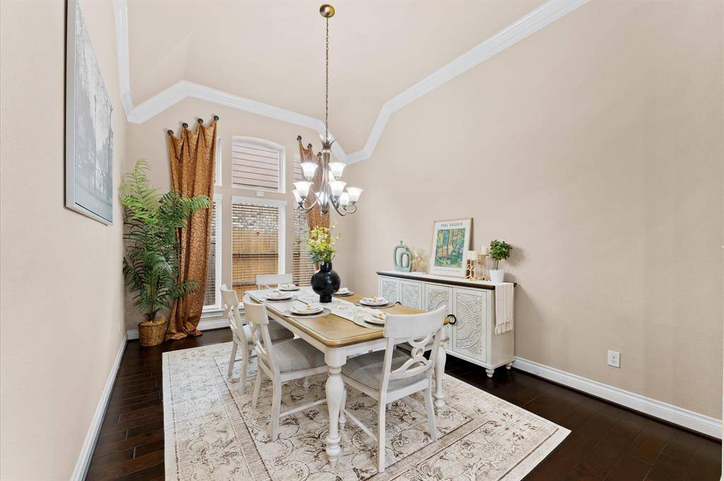 Gather with loved ones under a stunning chandelier that casts a warm glow over the elegant dining space.