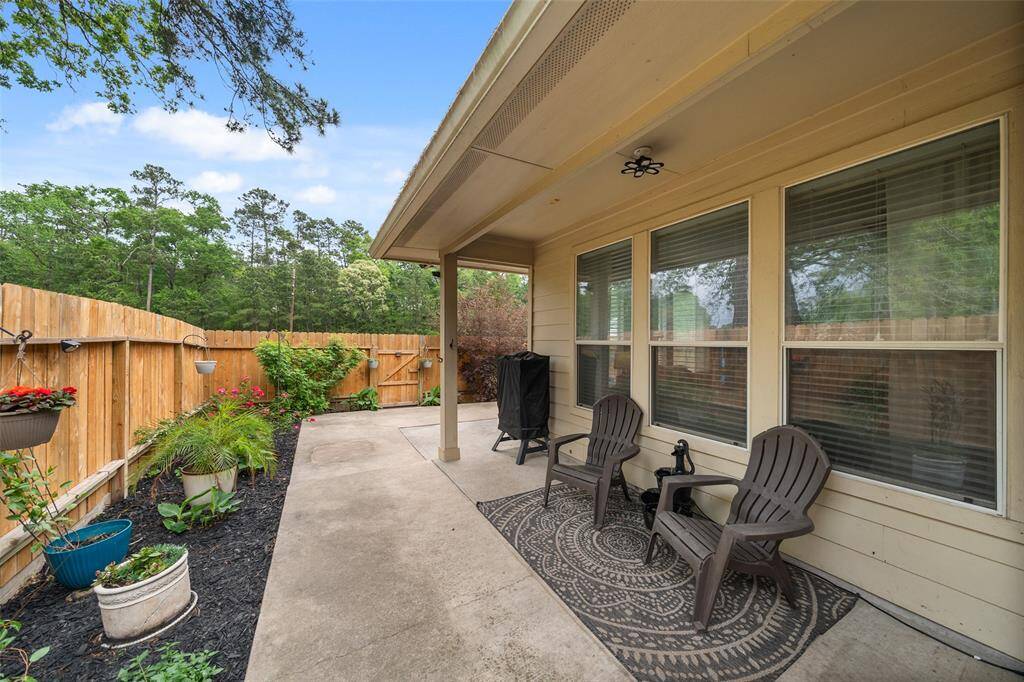 A serene backyard featuring lush greenery, with a fence framing the space and an expansive greenspace beyond, offering a peaceful, private setting perfect for relaxation and outdoor activities.