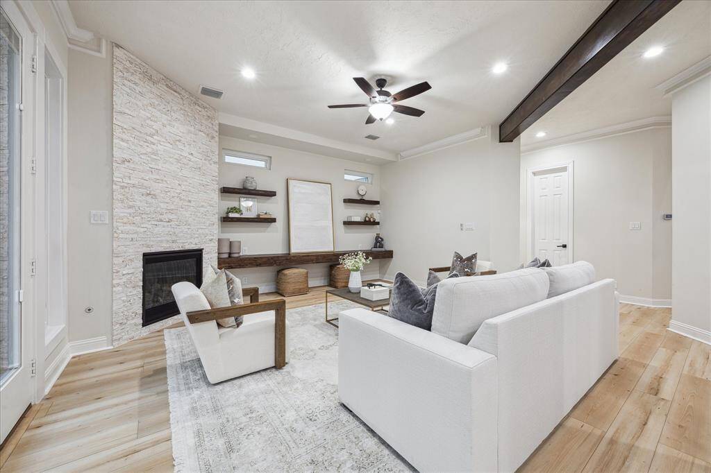 [FAMILY ROOM] The family room strikes the perfect balance between cozy and open, offering a warm and inviting atmosphere. Rich wood floors complement the light, neutral color palette, creating a timeless and airy feel. Thoughtfully designed floating display shelves add a stylish touch, perfect for showcasing décor or cherished keepsakes.