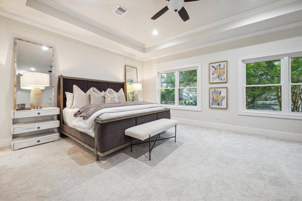 [PRIMARY BEDROOM] The primary bedroom is a spacious sanctuary featuring tray ceilings that add an elegant touch and enhance the room's sense of height and openness. Large windows invite abundant natural light, creating a bright and airy atmosphere while offering beautiful views of the outdoors.