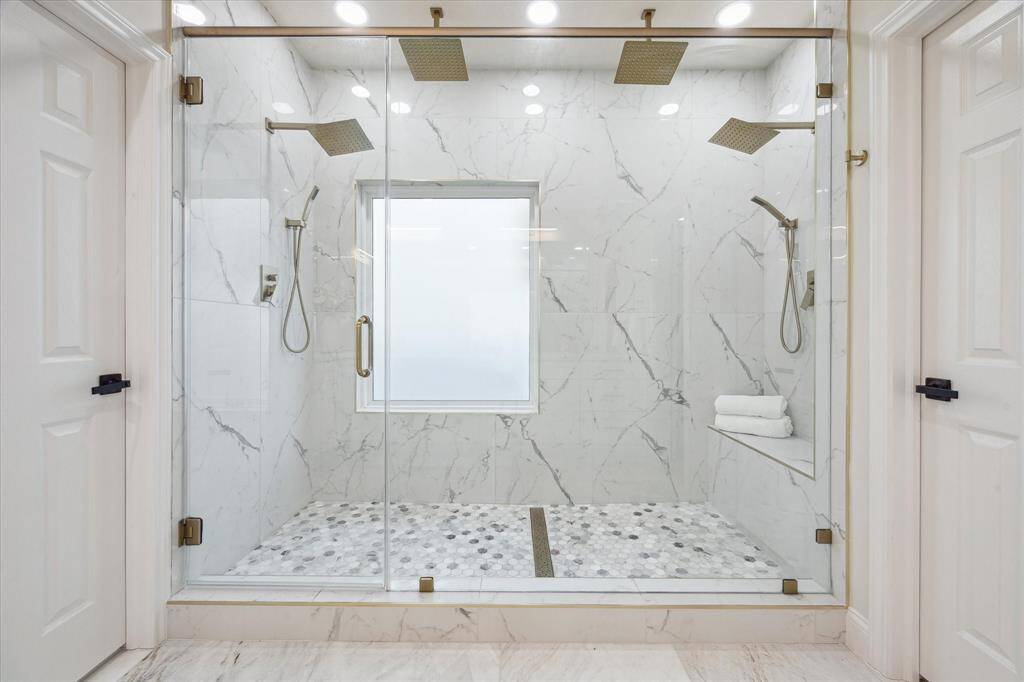 This is a dream shower with a frameless glass door and multiple spray options.
