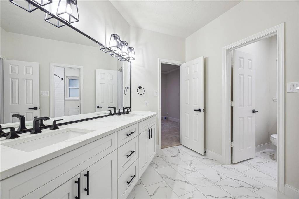 [SECONDARY BATHROOM] Dual sinks and plenty of counter and storage space.