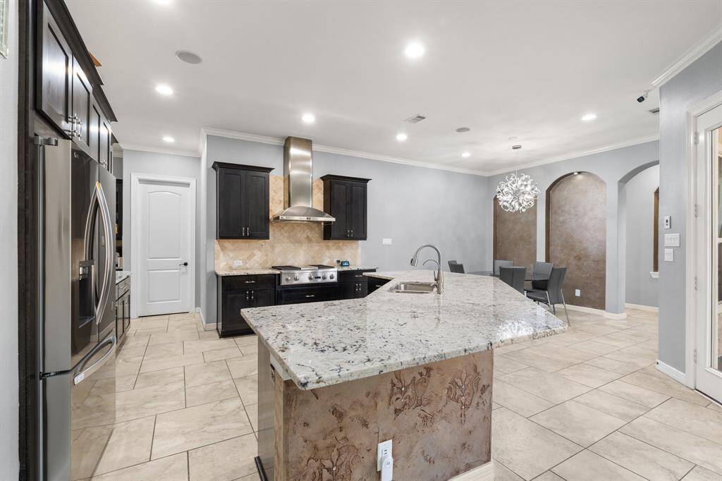 Welcome to the Gourmet Kitchen! The warm cabinetry, oversized island, breakfast bar for additional seating and custom backsplash are just a few of the highlights.