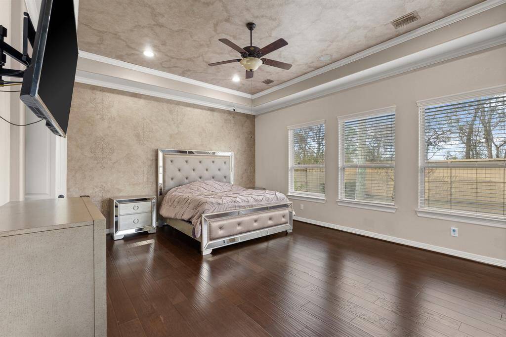 Welcome to the Prestigious Primary Suite, featuring gorgeous flooring, a WALL OF WINDOWS that flood the space with natural light, and a private sunroom perfect for relaxing or additional seating.