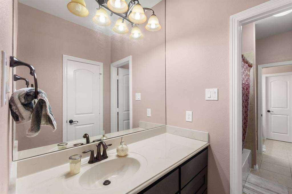 An additional view of the private Jack and Jill bathroom with extended countertop, modern finishes, and built-in storage.