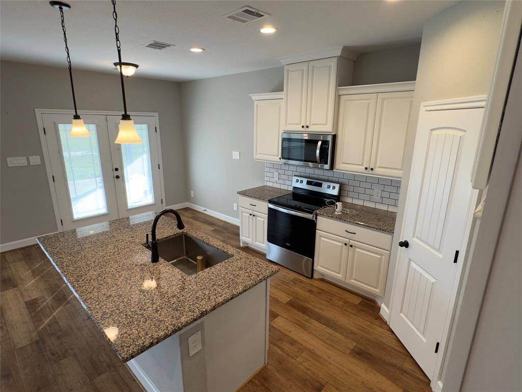Stunning kitchen with granite countertops, stainless steel appliances, and elegant pendant lighting. All perfect for culinary enthusiasts.
