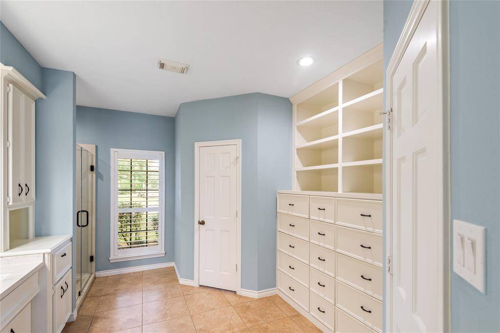 This primary en suite bath features double sinks and tons of counter space and storage.
