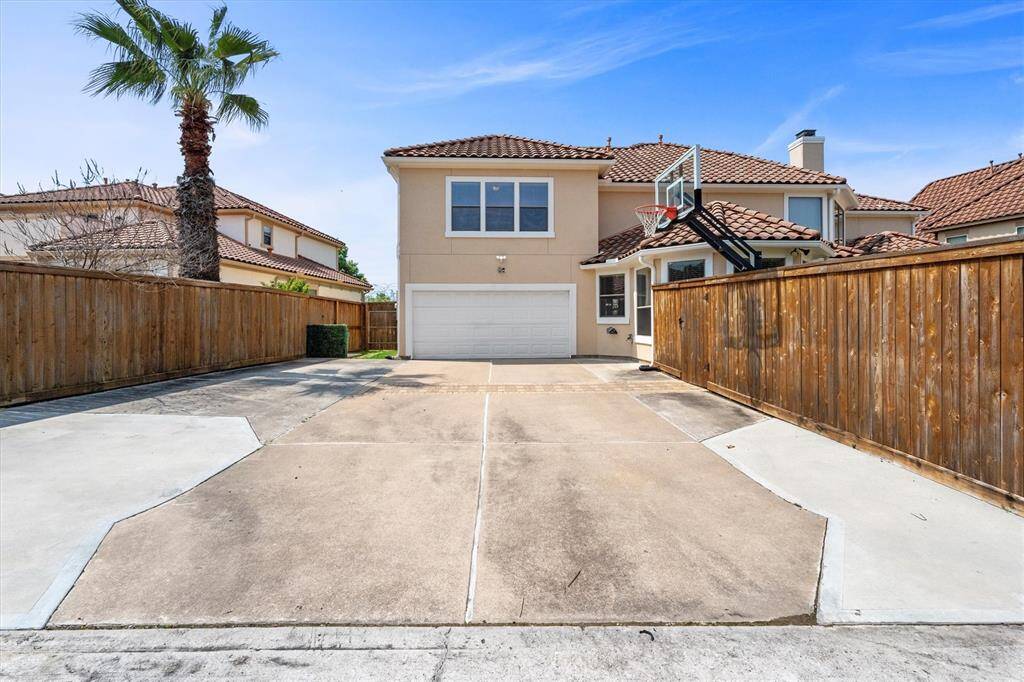 Back entrance to an oversized two-car garage with three additional parking spots