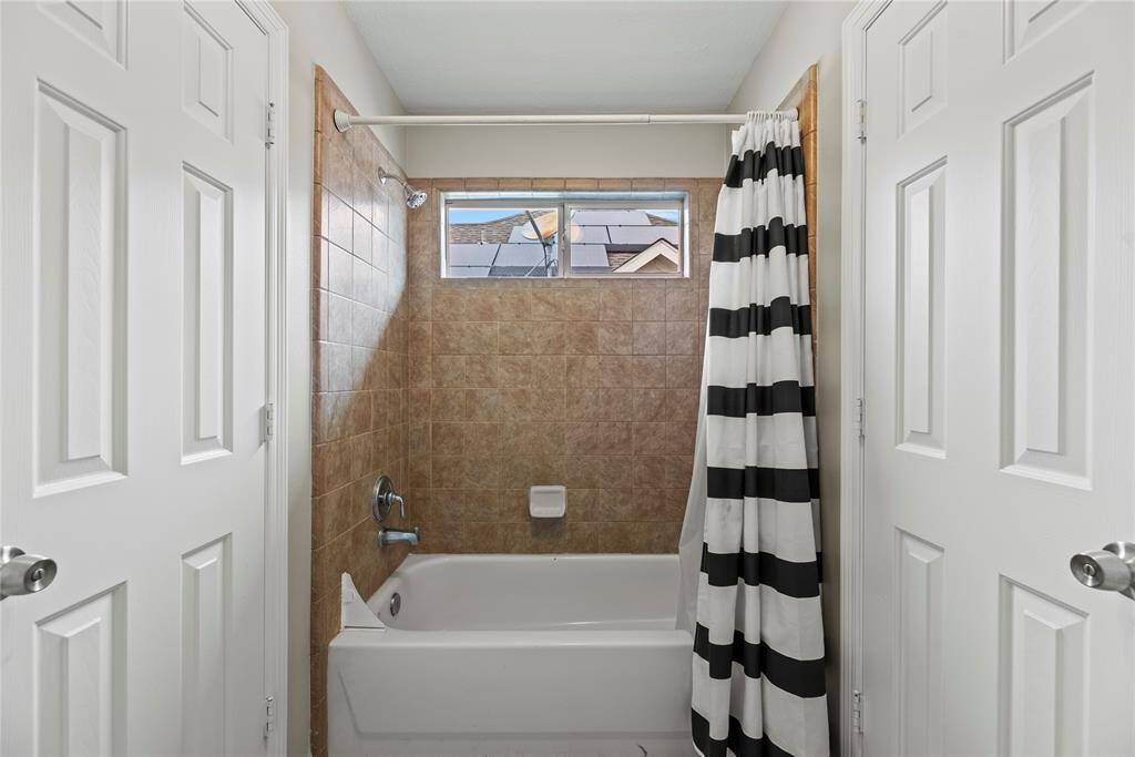 The Hollywood bathroom upstairs offers a shared water closet with a fully tiled tub/shower enclosure and toilet.